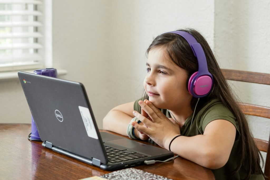 A middle school student looks at a laptop.