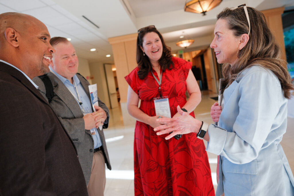 Four conference attendees chat animatedly.