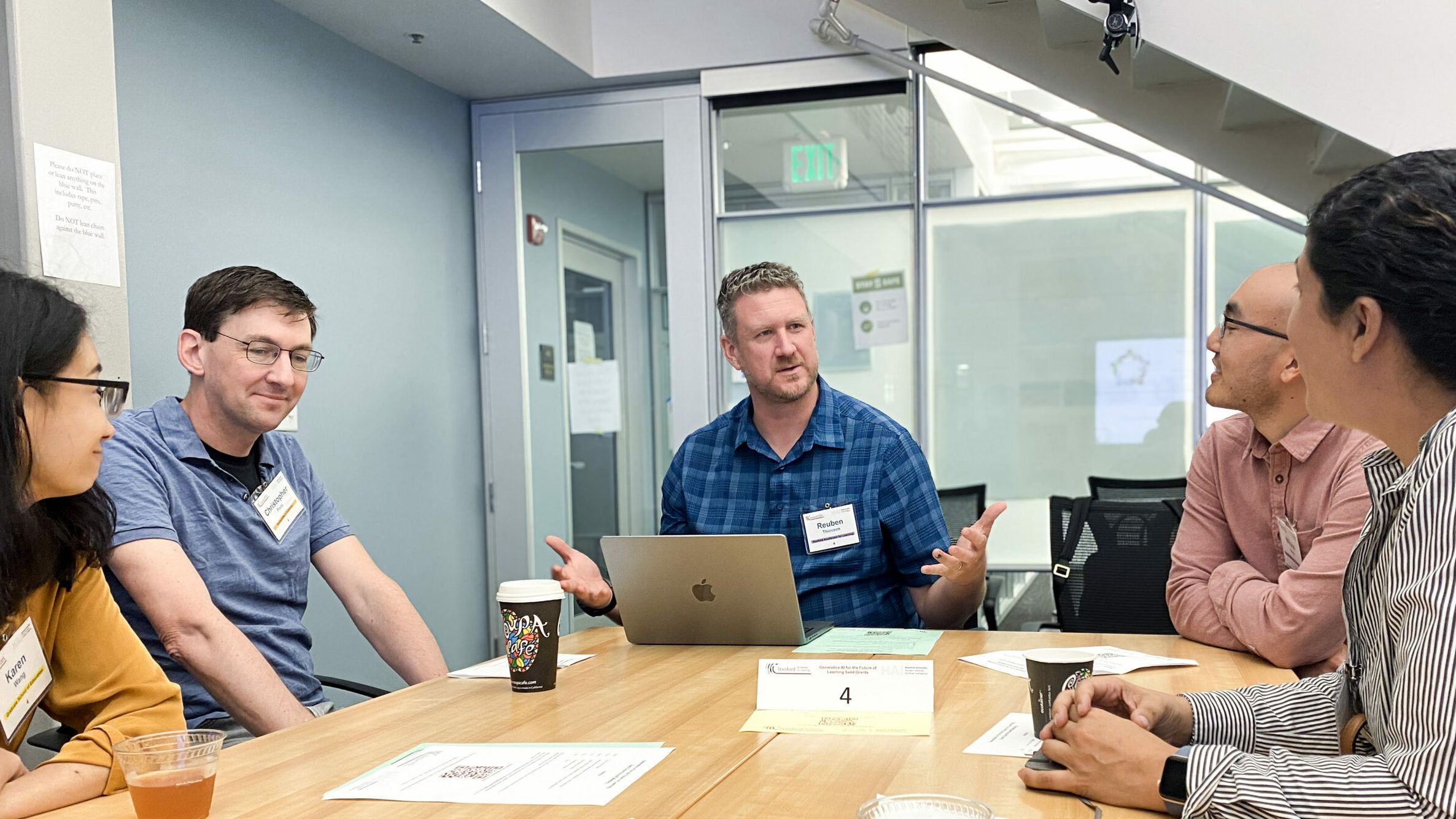 Reuben Thiessen chats with a group of people around a conference table.