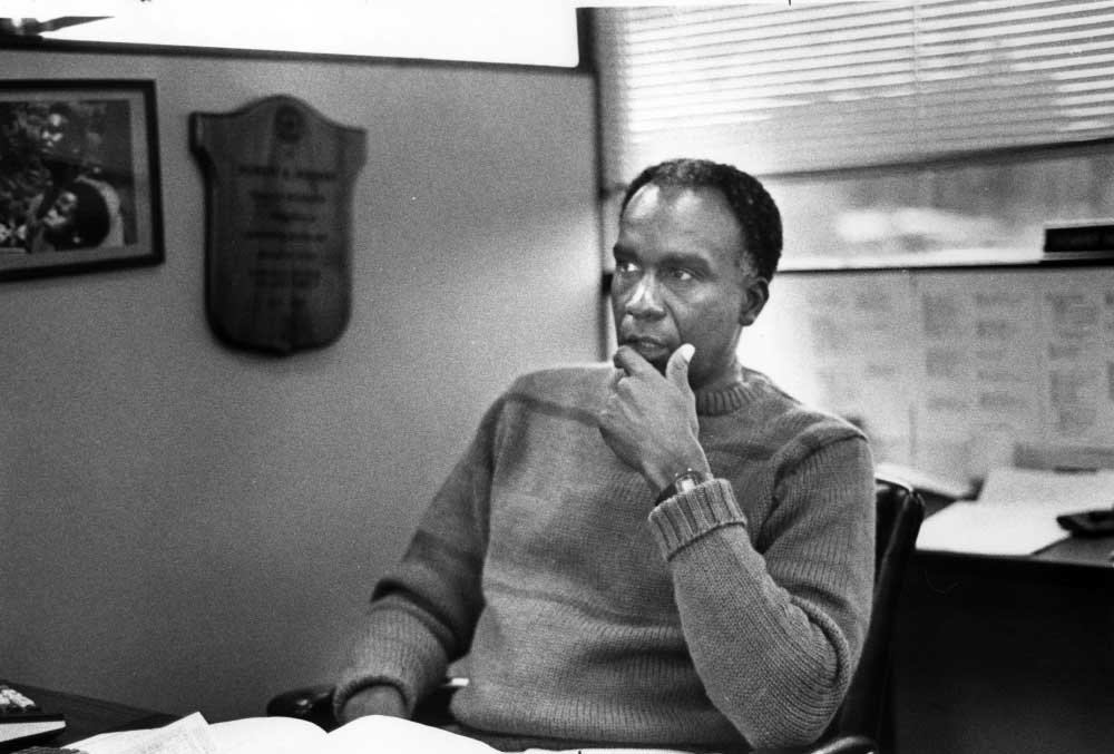 Black and white image of Bob Hoover sitting at a desk in 1984.