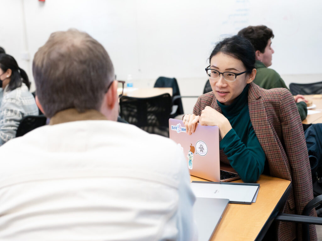 Two seed grantees chat over a laptop.