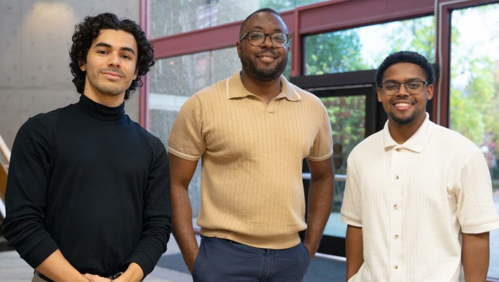 Professor Mike Hines smiles with two STEP students.