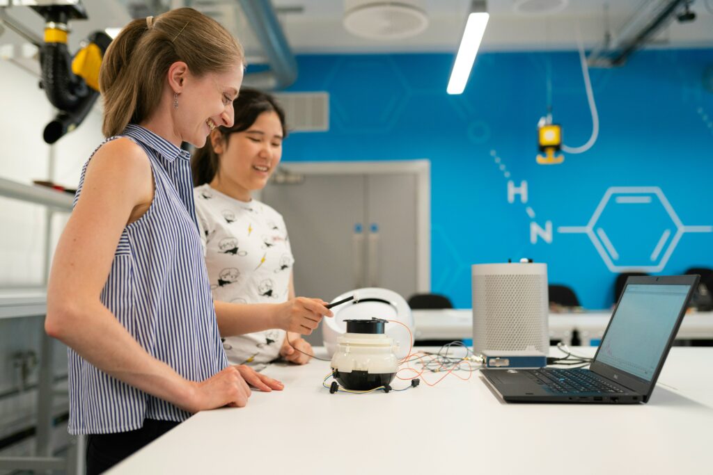 A female teacher and student work on a robotics program together.