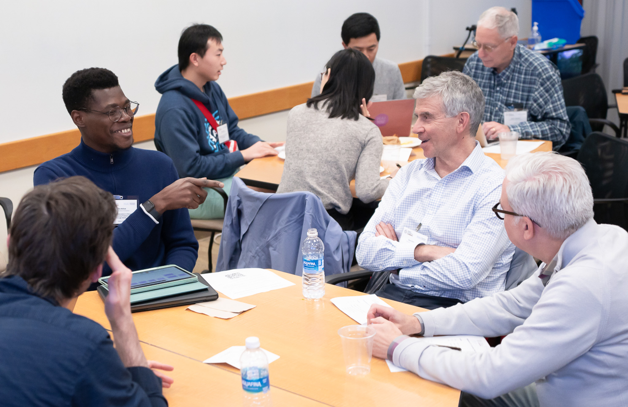 A group of faculty and students chat at a table at a seed grant event.
