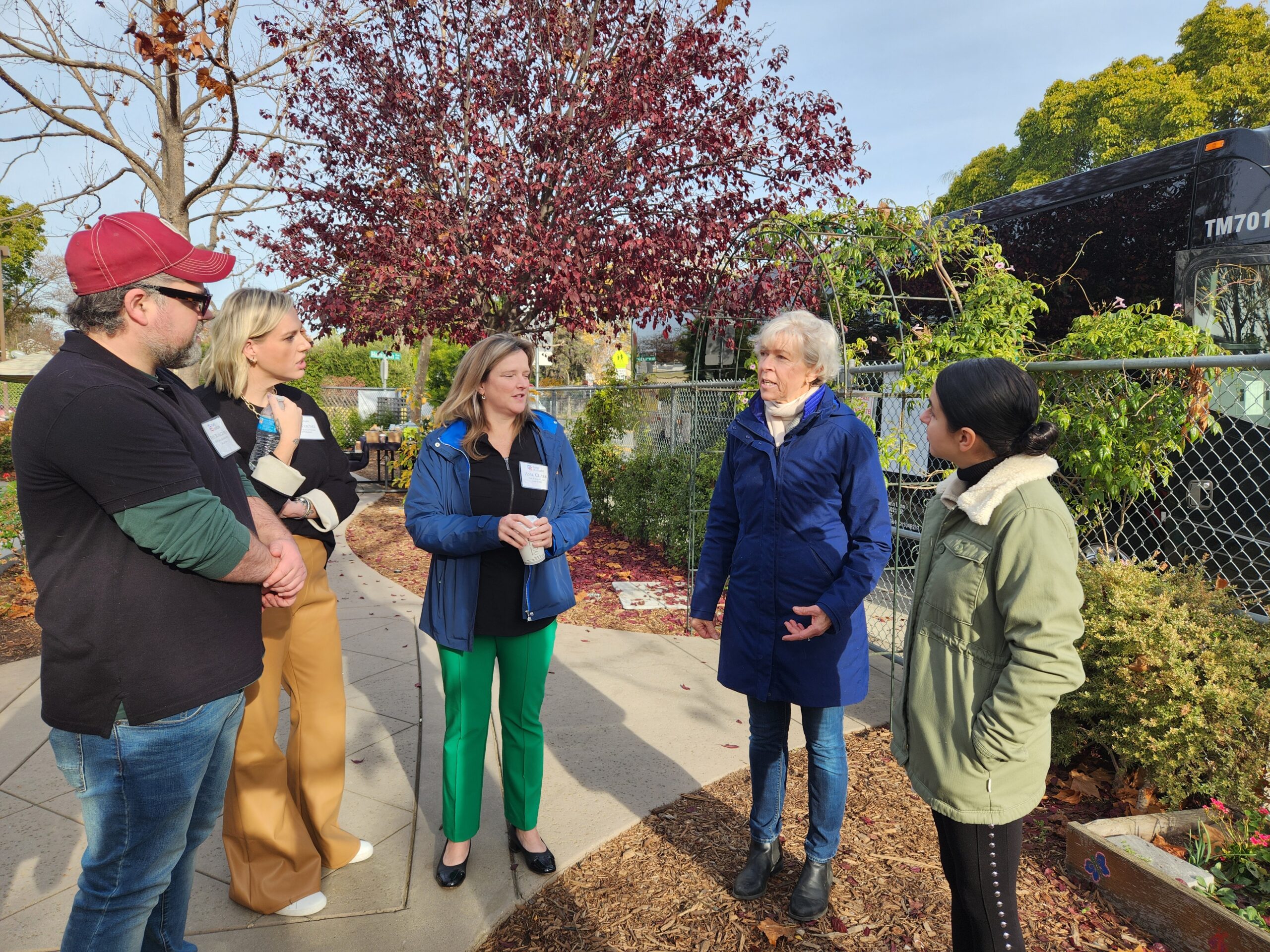 A group of adults stand together chatting.