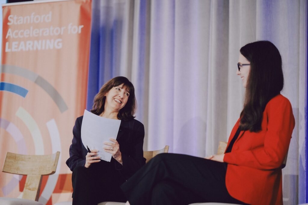 Denise Pope smiles at Randi Michel on stage.