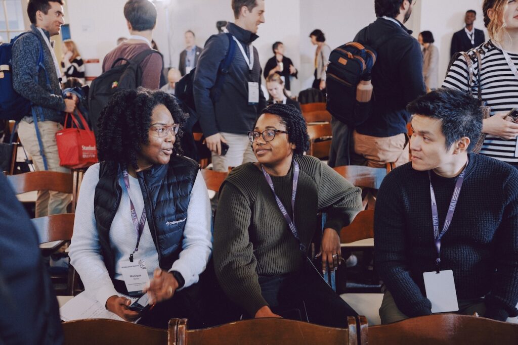 Three attendees chat during a break.