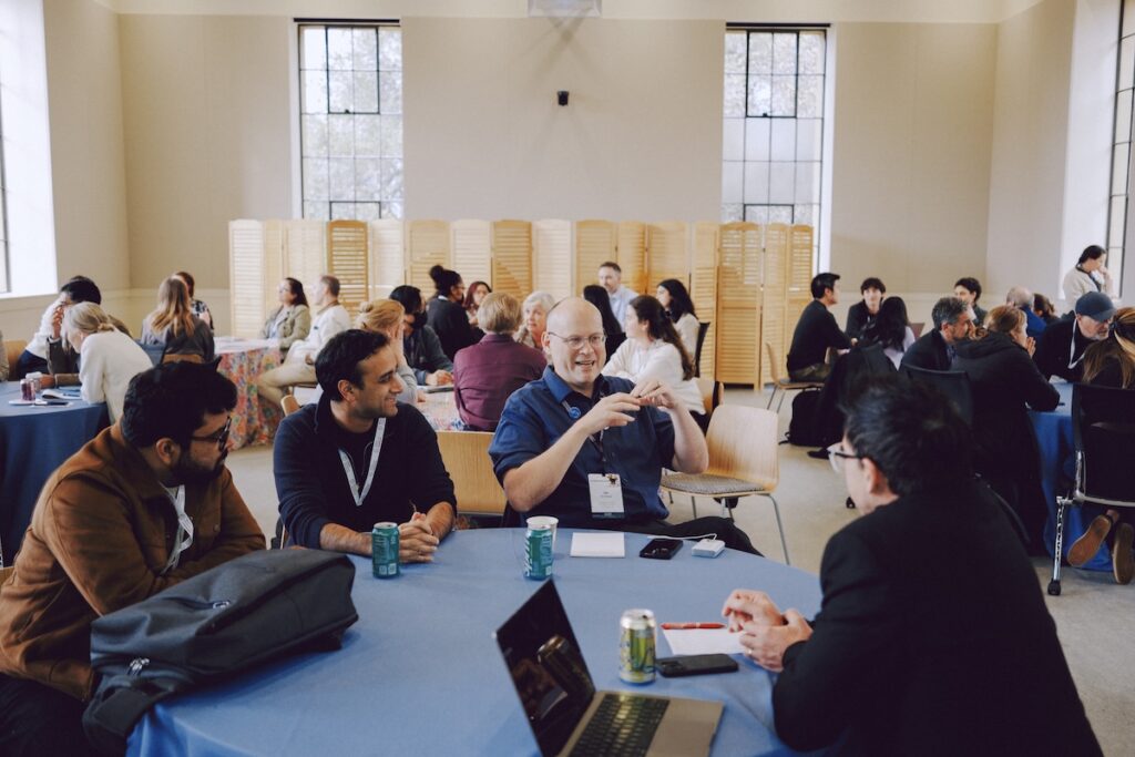 Attendees discuss heartily at a round table.