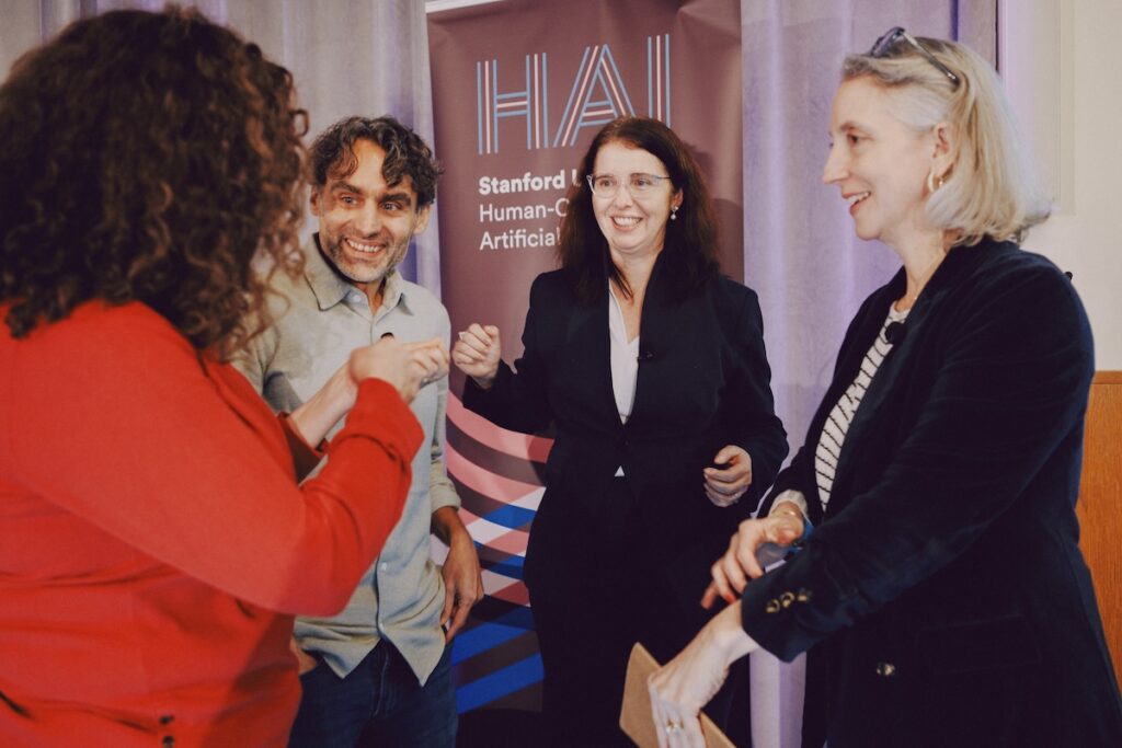 Panelists share a laugh offstage.