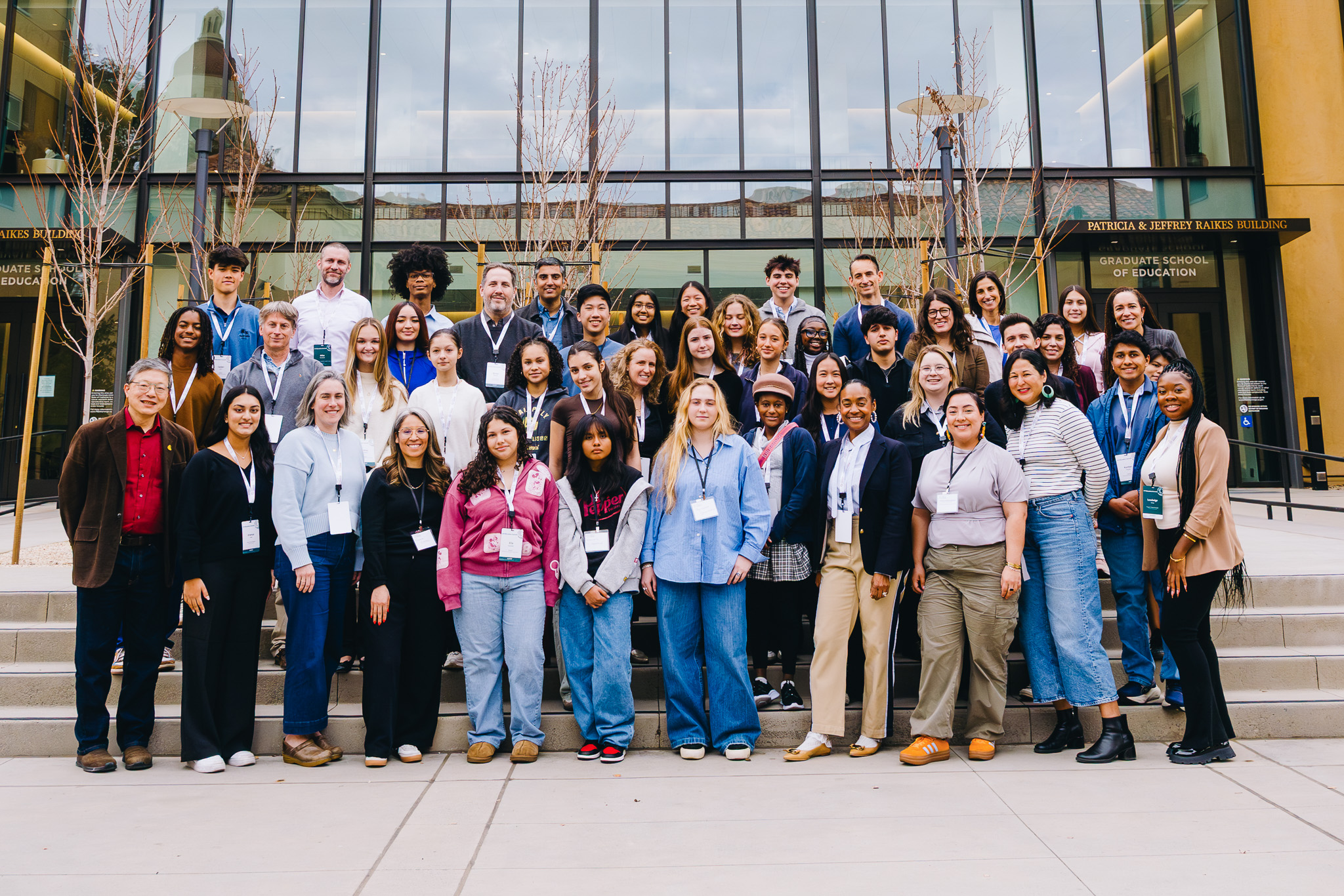 A large group of high school students and teachers pose outside the Stanford Graduate School of Education.