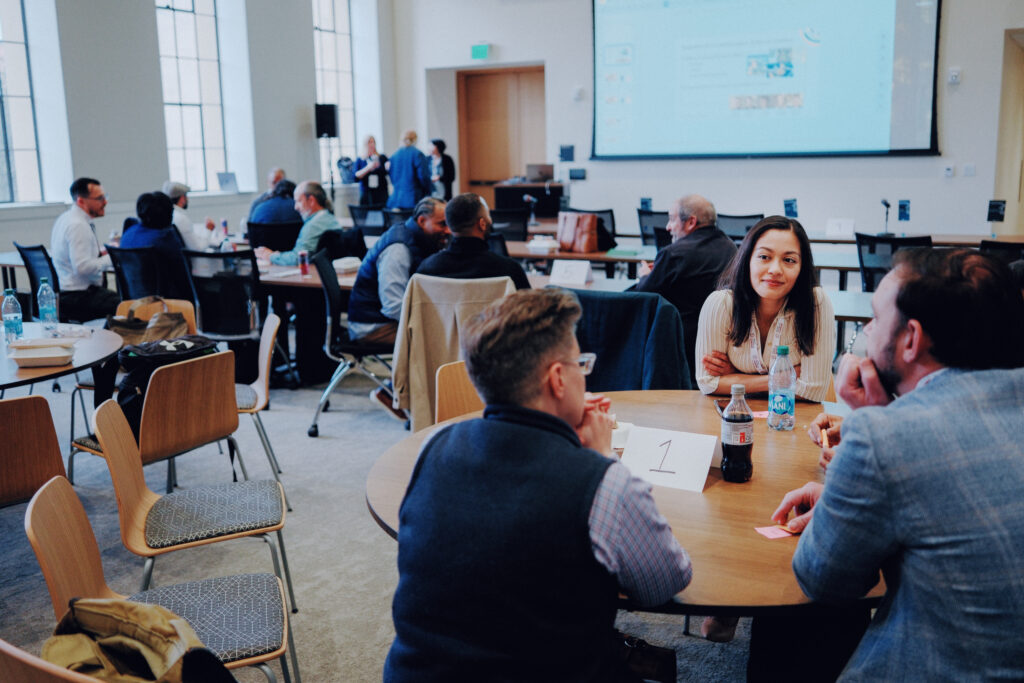 A group of education entrepreneurs has a heartfelt discussion in a conference room.