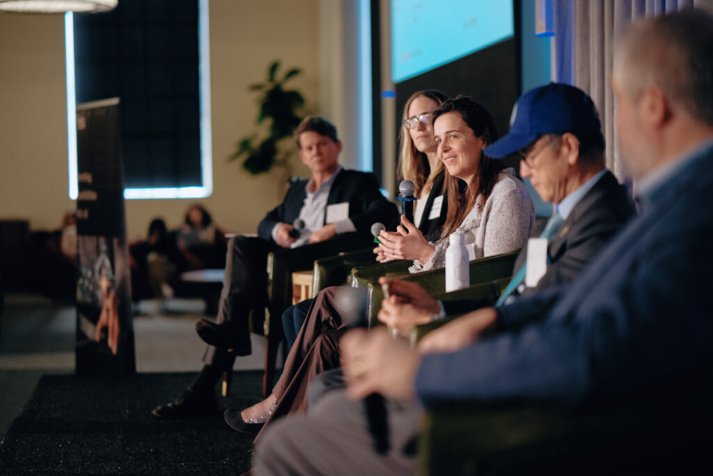 A group of speakers onstage at a conference.